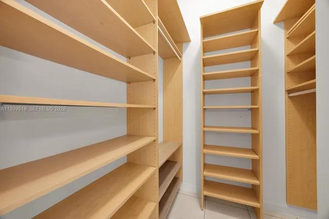 a view of walk in closet with empty racks
