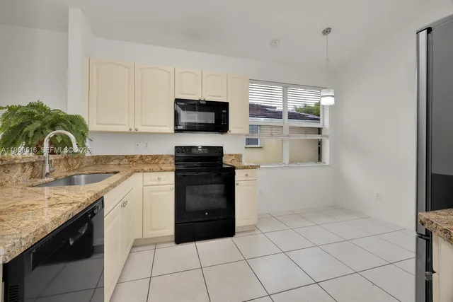 a kitchen with a sink and a stove top oven with wooden floor