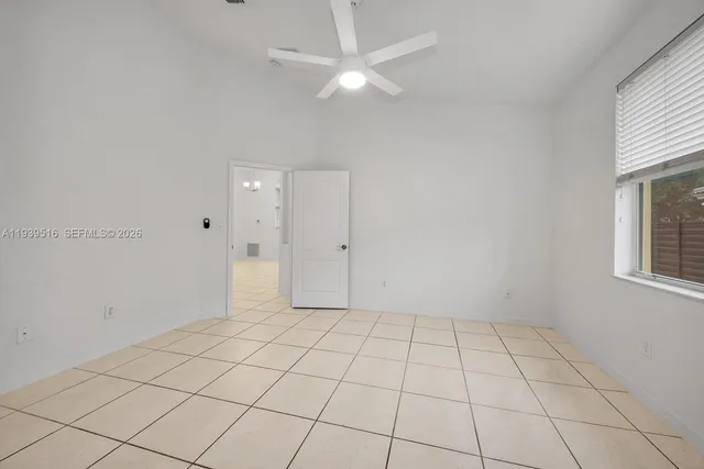an empty room with windows and fan