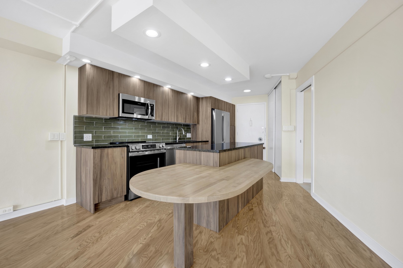 300 North State Street, Unit 4512 Chicago, IL 60654 - Photo 5 of 21 a kitchen with kitchen island a stove a table and a refrigerator