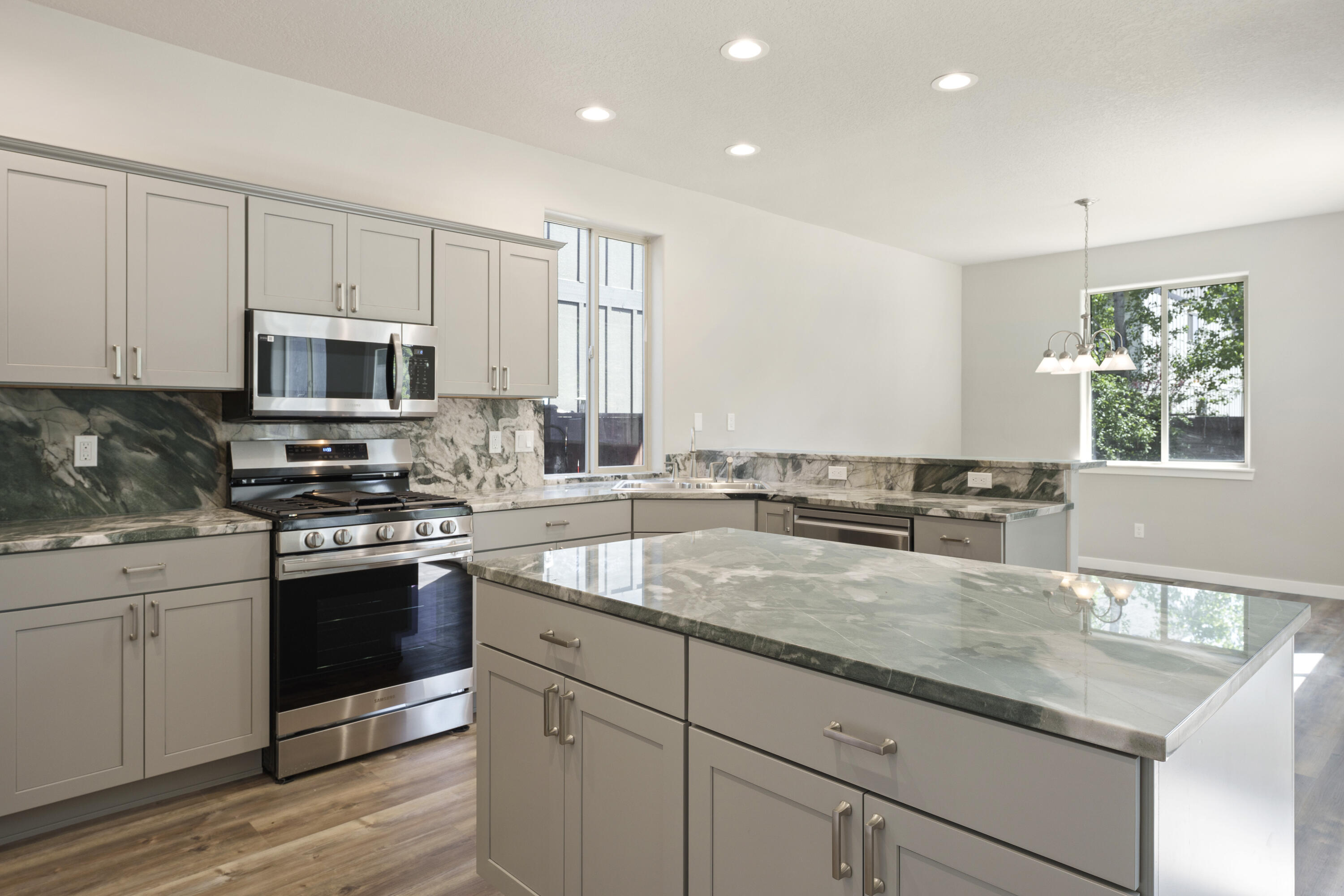 21189 Ritz Place Bend, OR 97702 - Photo 2 of 37 a kitchen with granite countertop a sink stainless steel appliances and white cabinets