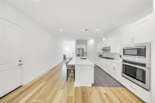 a kitchen with stainless steel appliances kitchen island granite countertop a stove a sink and a microwave