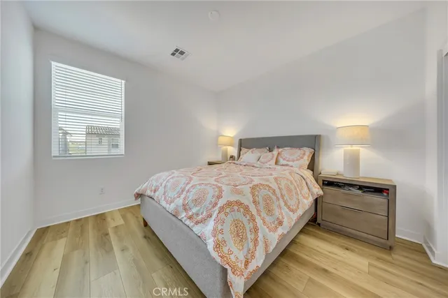 a bedroom with a bed and wooden floor
