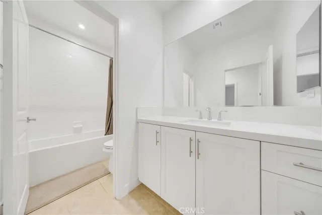 a bathroom with a double vanity sink a mirror and a bathtub