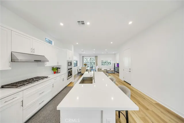a kitchen with kitchen island a stove a table and chairs in it