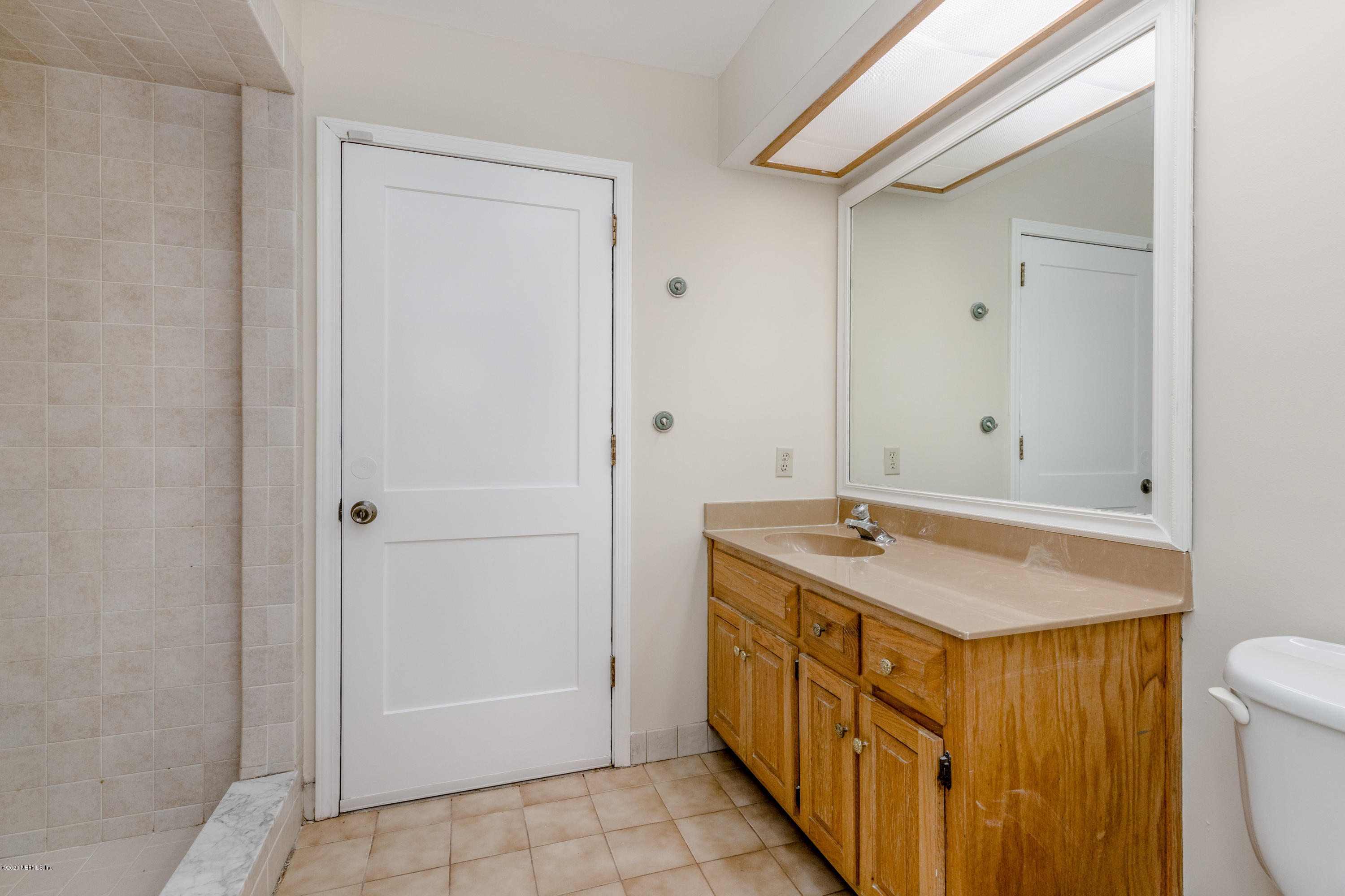 1704 Memory Lane Jacksonville, FL 32210 - Photo 17 of 54 a bathroom with a granite countertop sink and a mirror