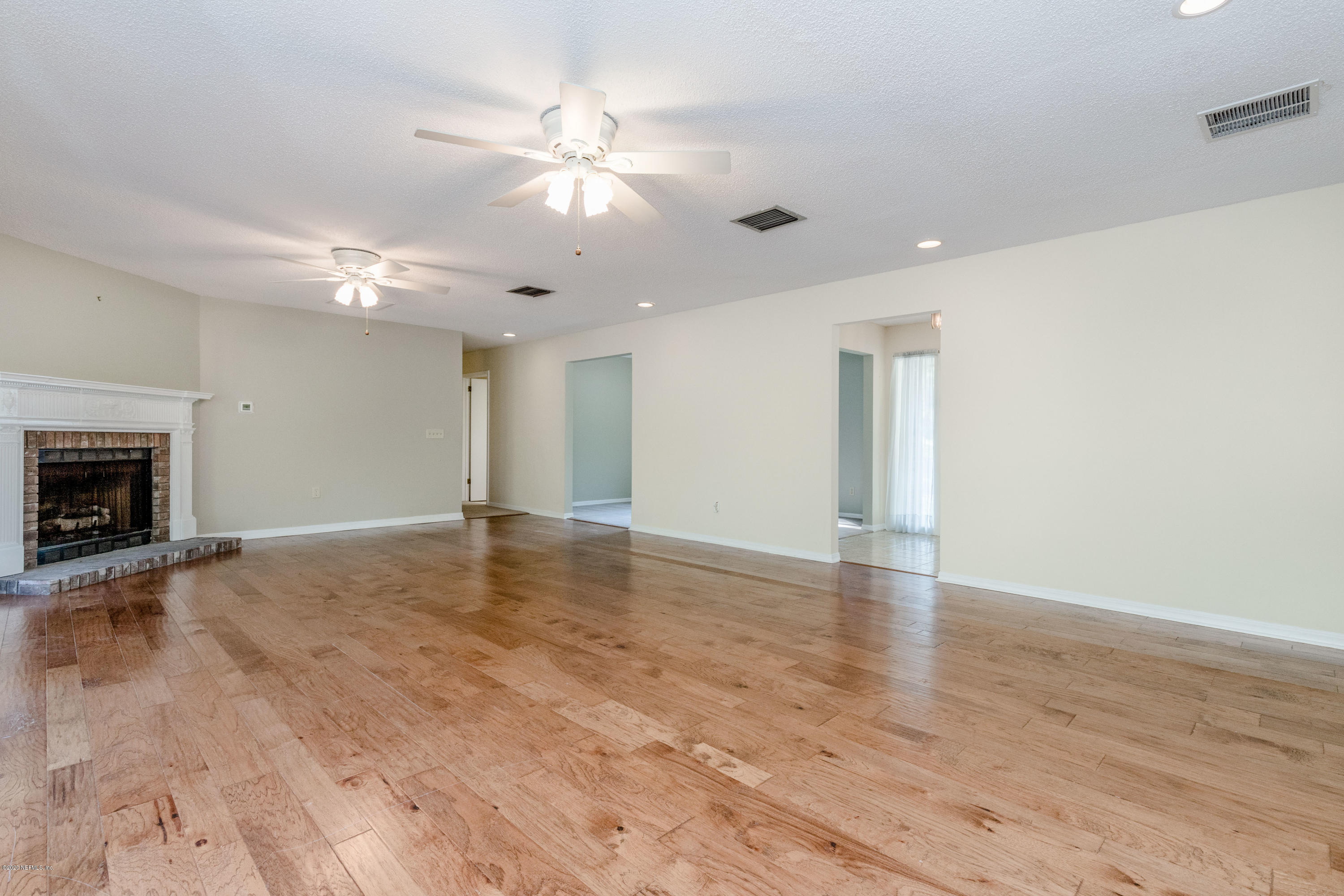 1704 Memory Lane Jacksonville, FL 32210 - Photo 42 of 54 a view of an empty room with wooden floor and fireplace