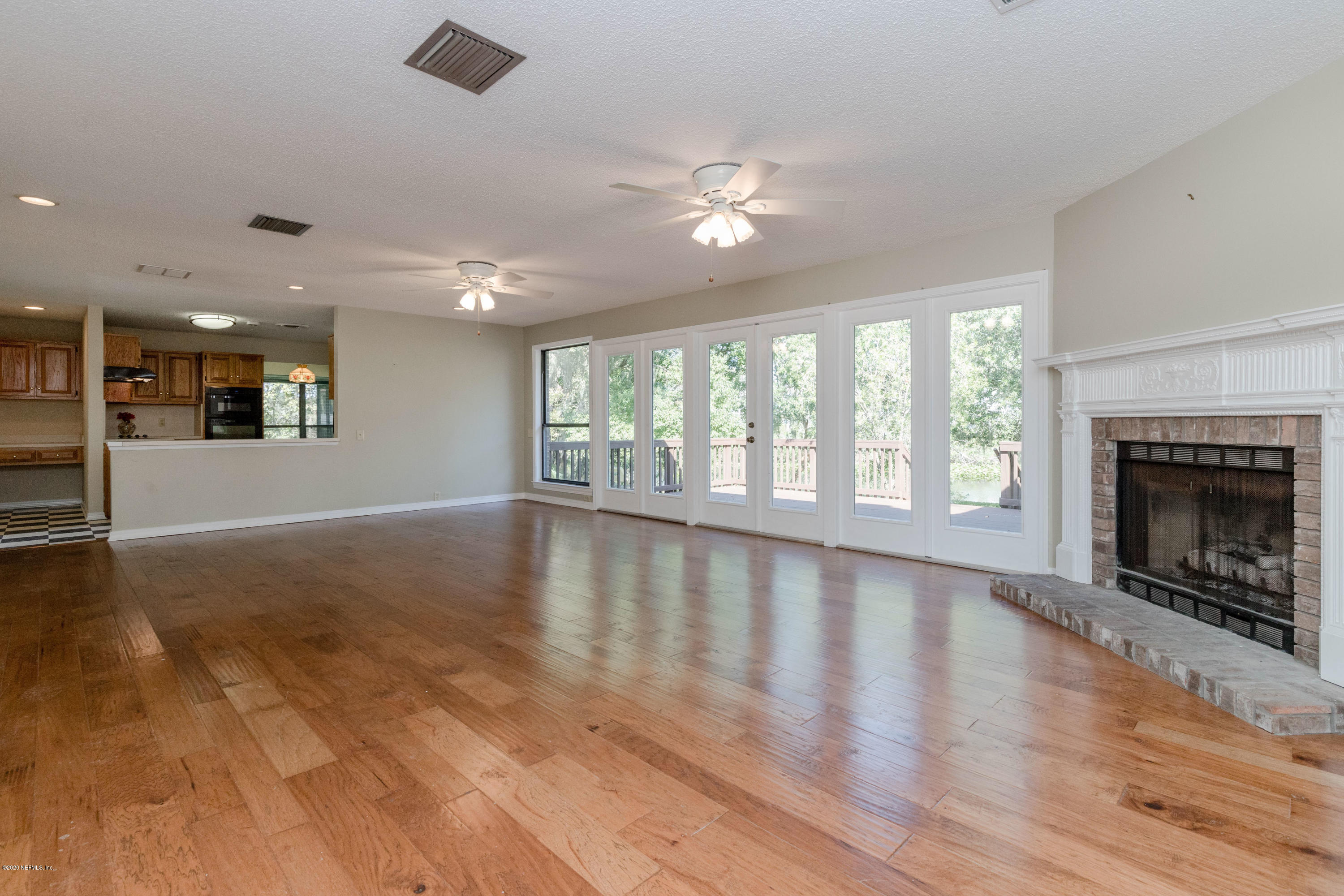 1704 Memory Lane Jacksonville, FL 32210 - Photo 5 of 54 an empty room with wooden floor fireplace and windows