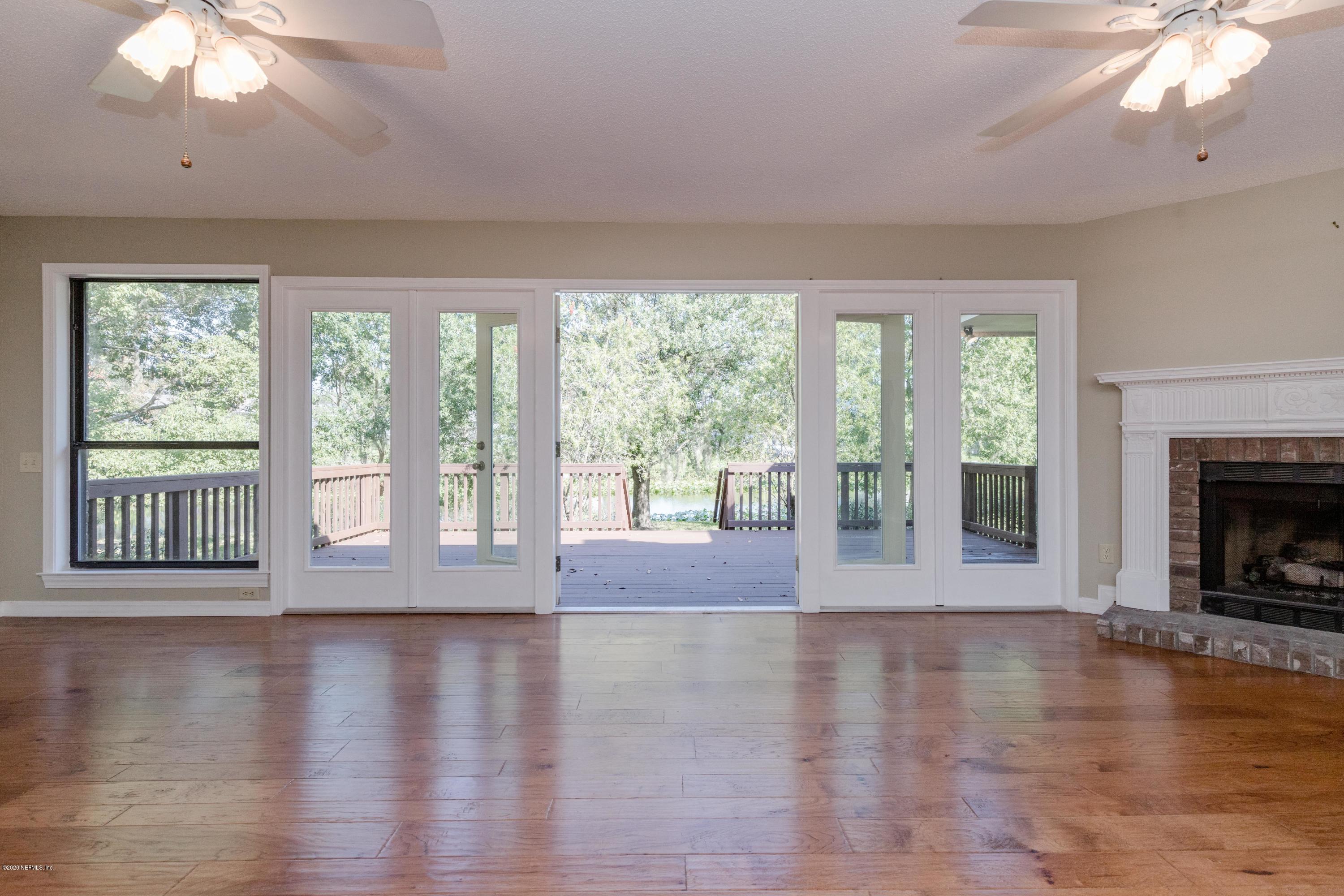 1704 Memory Lane Jacksonville, FL 32210 - Photo 7 of 54 a view of an empty room with wooden floor and a window