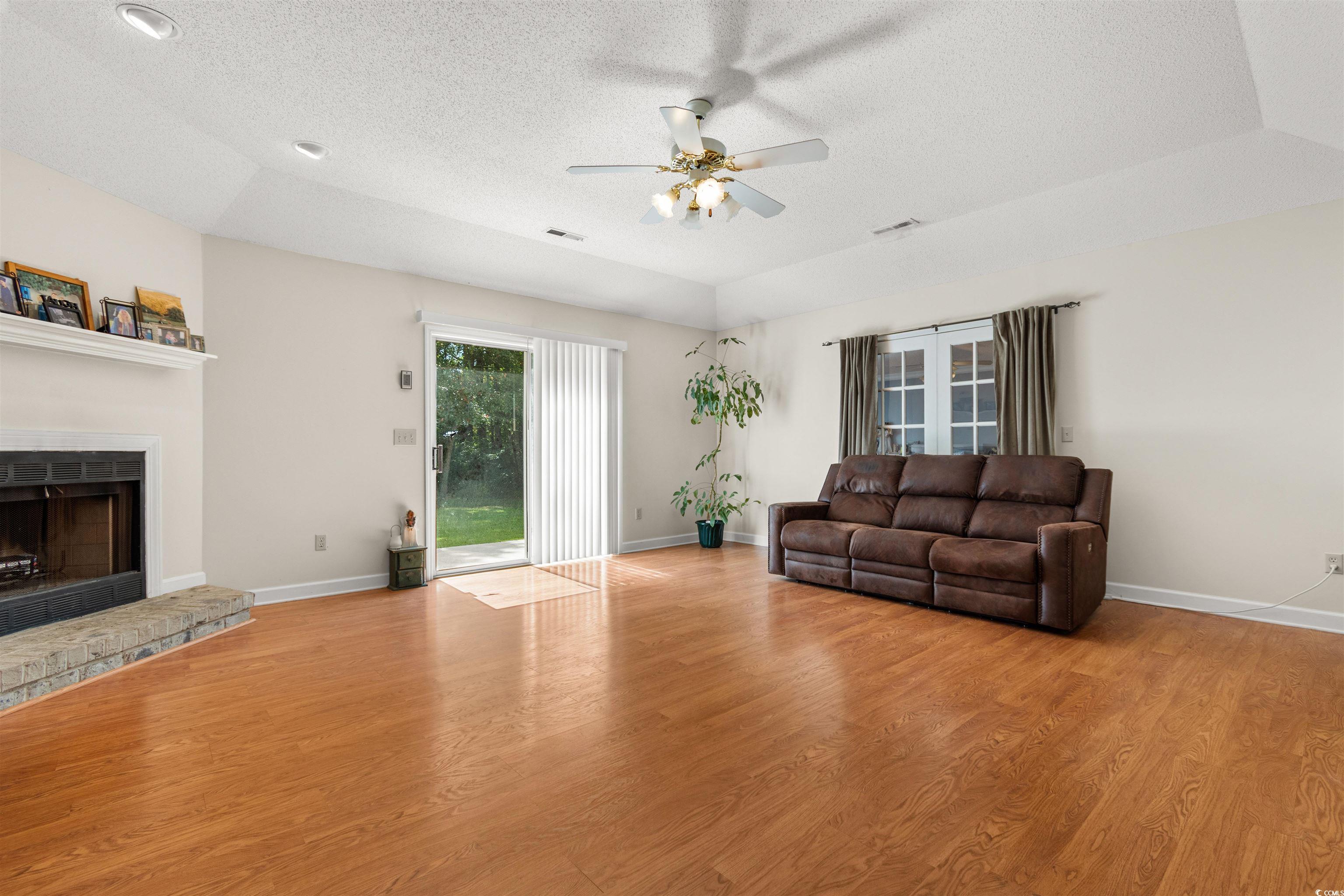 203 Prestwick Road Myrtle Beach, SC 29588 - Photo 4 of 34 Living room featuring a tray ceiling, a textured c