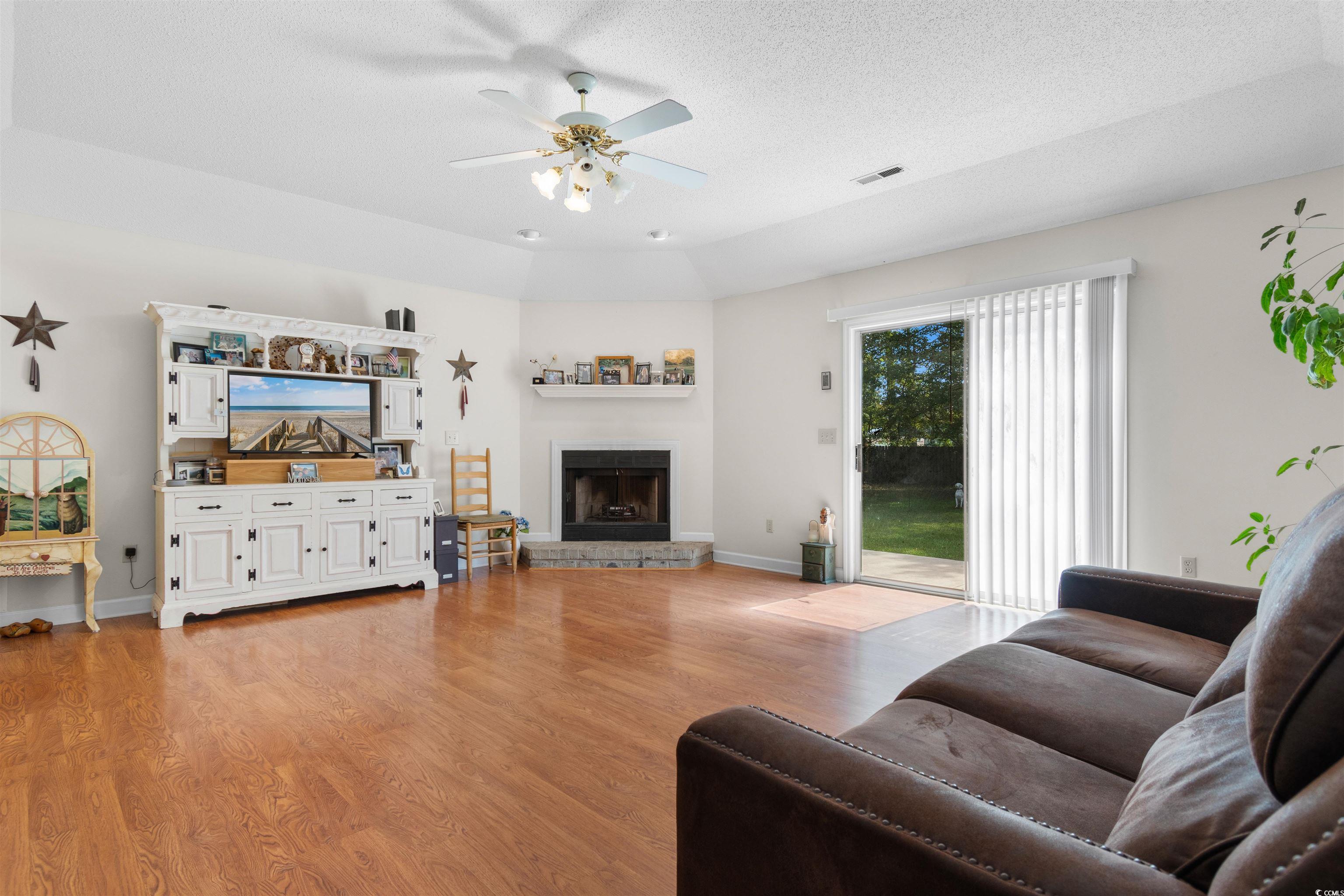 203 Prestwick Road Myrtle Beach, SC 29588 - Photo 5 of 34 Living room featuring a fireplace, a textured ceil