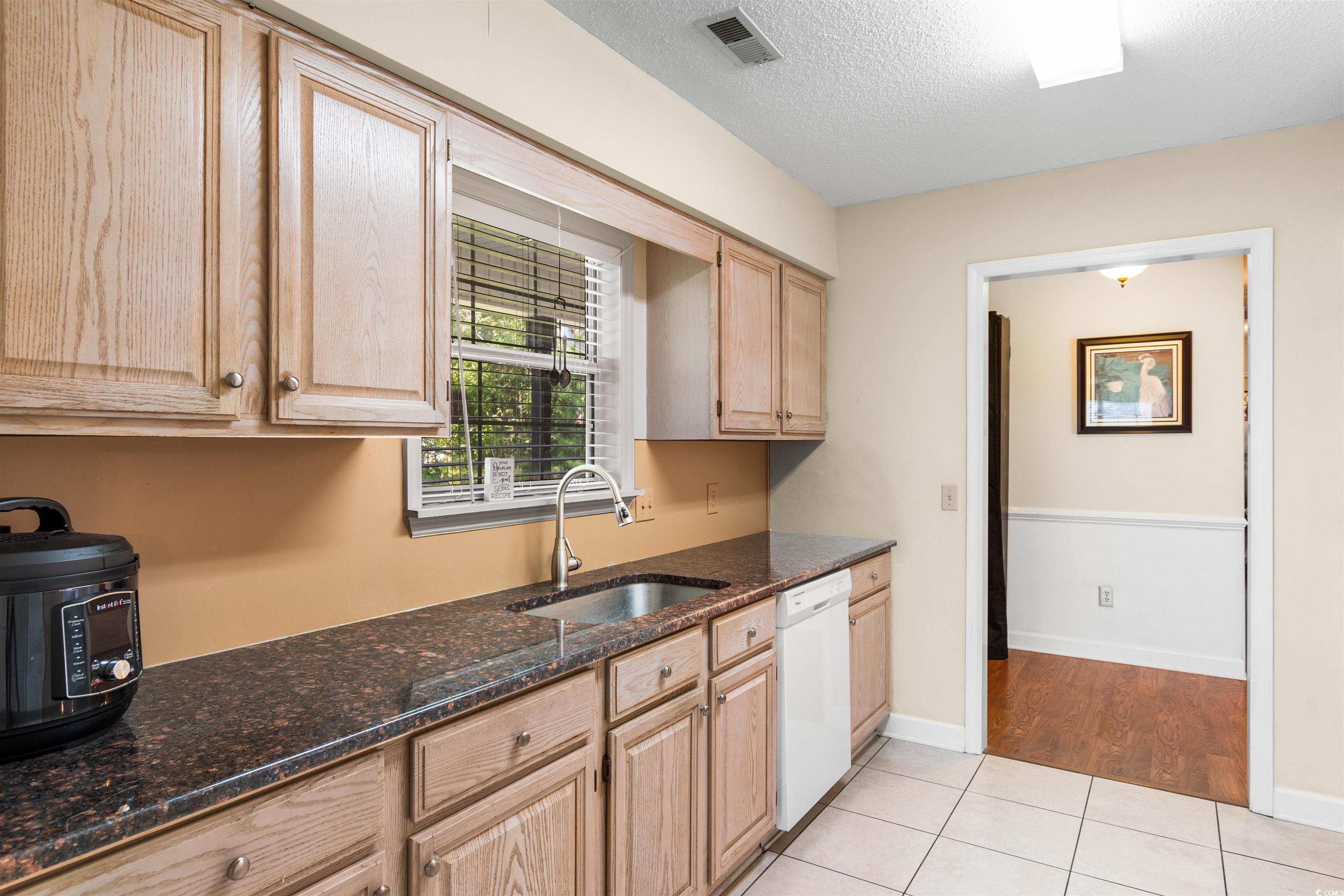 203 Prestwick Road Myrtle Beach, SC 29588 - Photo 9 of 34 Kitchen with dark stone countertops, white dishwas