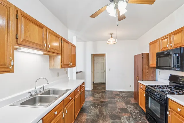 a kitchen with stainless steel appliances granite countertop a sink a stove and a refrigerator