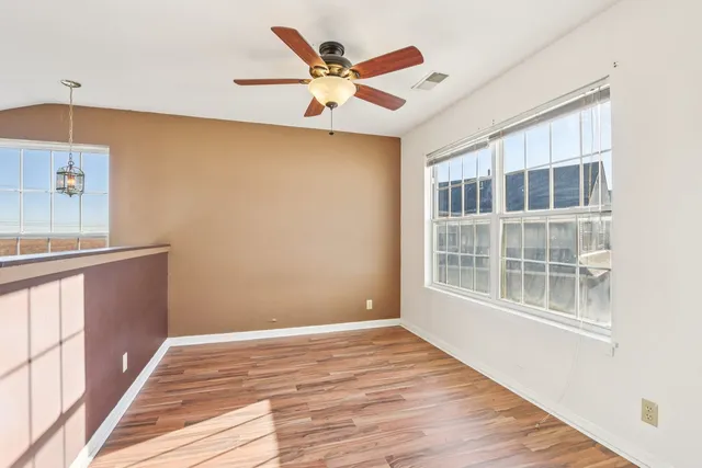 a view of a livingroom with a ceiling fan and wooden floor
