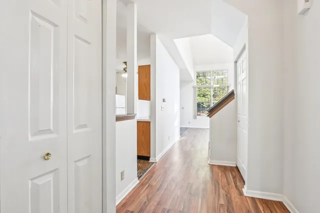 a view of a hallway with wooden floor and staircase