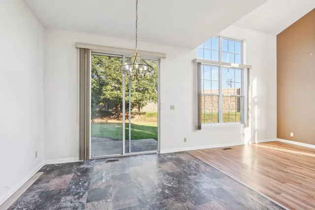 a view of an empty room with glass door and windows