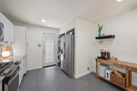 a view of a kitchen with fridge and wooden floor