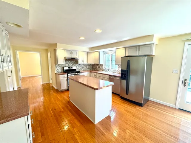 a kitchen with stainless steel appliances granite countertop a refrigerator and a stove top oven
