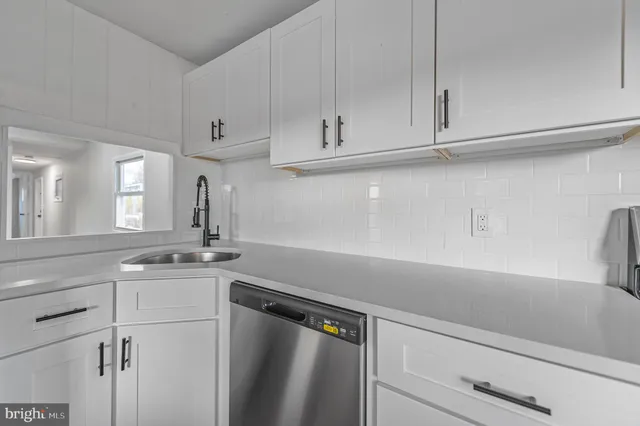 a kitchen with stainless steel appliances white cabinets and a stove top oven