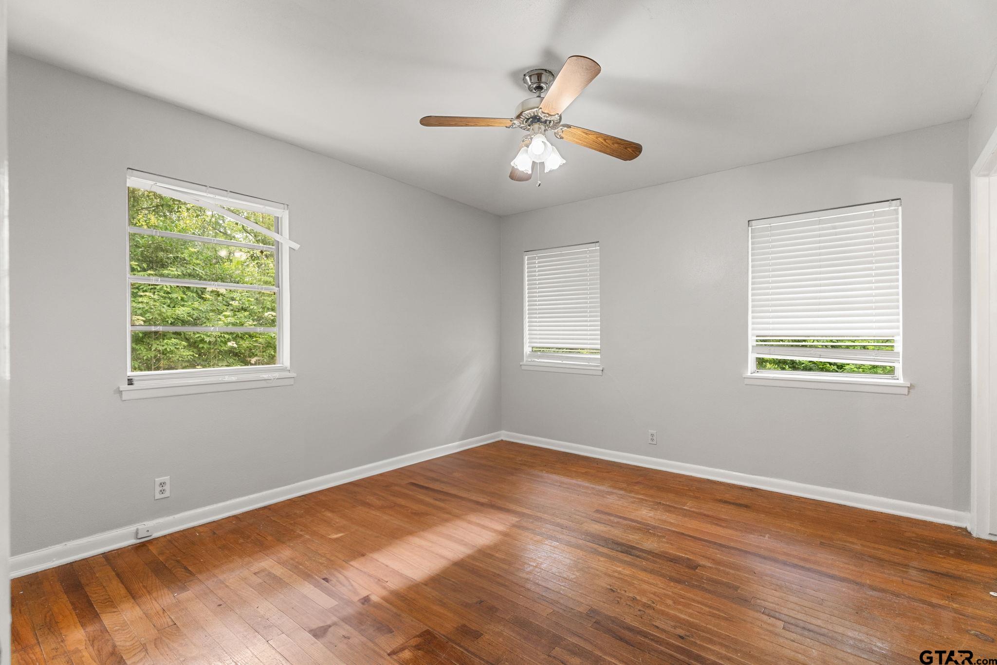 2811 Rollingwood Drive Tyler, TX 75701 - Photo 13 of 28 a view of a room with wooden floor and chandelier fan