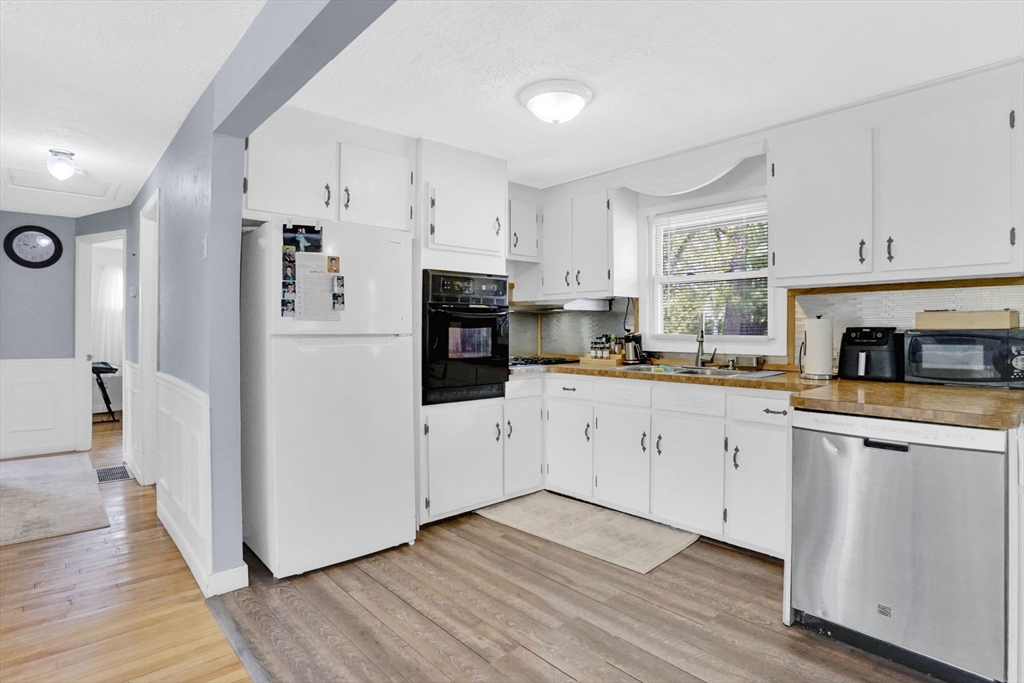 94 Cora Avenue Chicopee, MA 01013 - Photo 15 of 41 a kitchen with cabinets wooden floor and a refrigerator