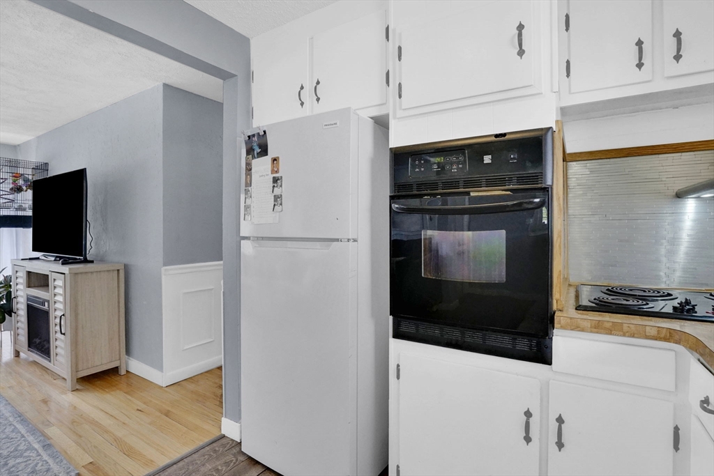 94 Cora Avenue Chicopee, MA 01013 - Photo 18 of 41 a kitchen with a refrigerator stove and white cabinets