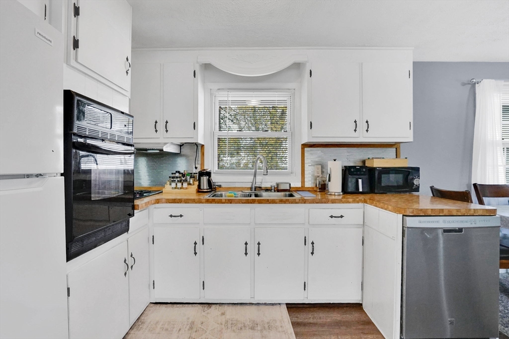 94 Cora Avenue Chicopee, MA 01013 - Photo 20 of 41 a kitchen with white cabinets and window