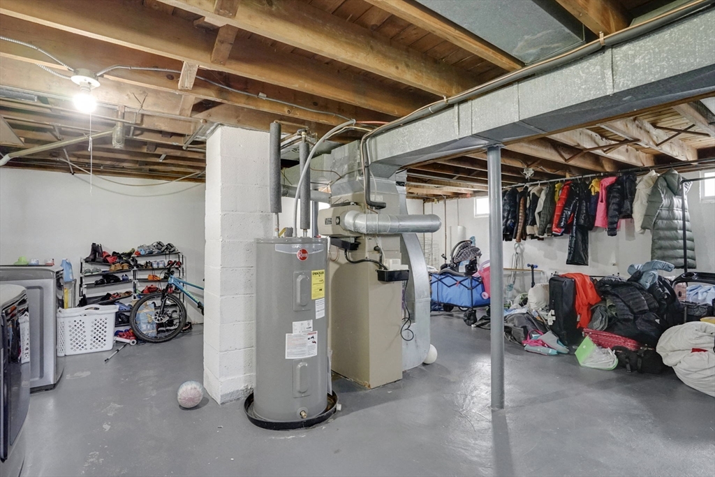 94 Cora Avenue Chicopee, MA 01013 - Photo 40 of 41 a view of a storage room with water heater and racks