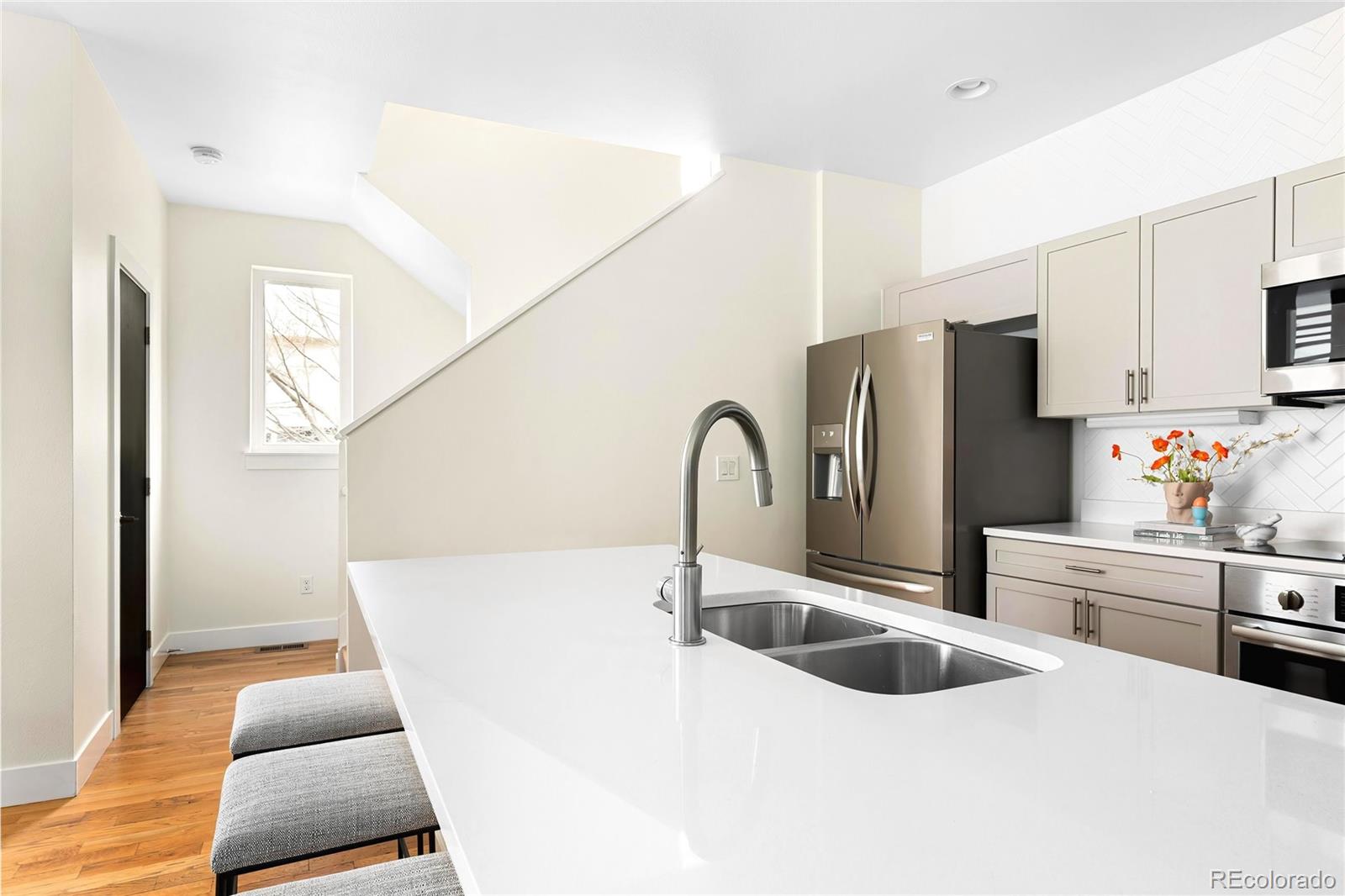 3166 Vallejo Street Denver, CO 80211 - Photo 18 of 50 a kitchen with stainless steel appliances a sink a stove a refrigerator a counter space and cabinets