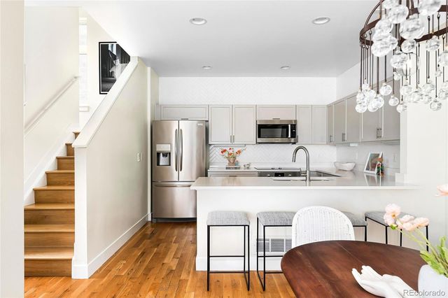 a kitchen with stainless steel appliances granite countertop a microwave a stove and white cabinets