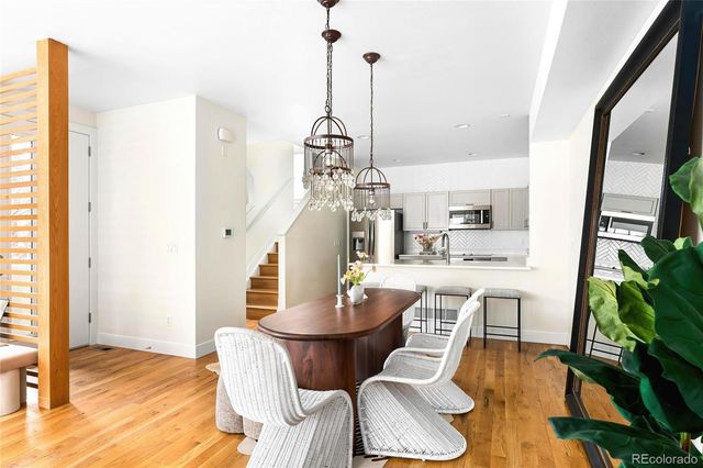 a dining room with furniture a chandelier and wooden floor