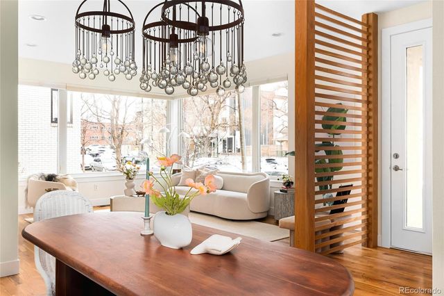a dining room with furniture a chandelier and wooden floor