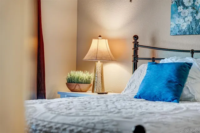a bedroom with a bed a chandelier and a dresser