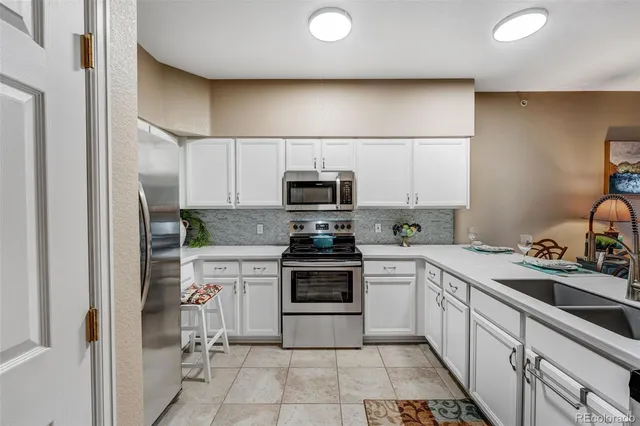 a kitchen with a stove sink and cabinets