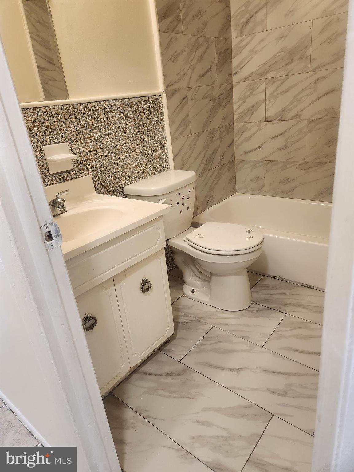 4320 Howell Street, Unit 1 Philadelphia, PA 19135 - Photo 14 of 19 a white toilet sitting next to a bathroom sink