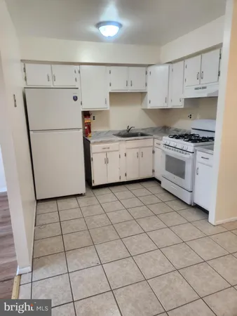 a kitchen with a white cabinets and white appliances