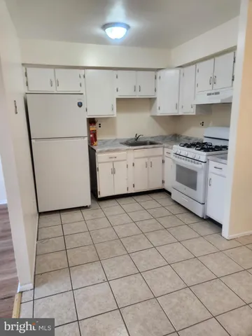 a kitchen with a white cabinets and white appliances