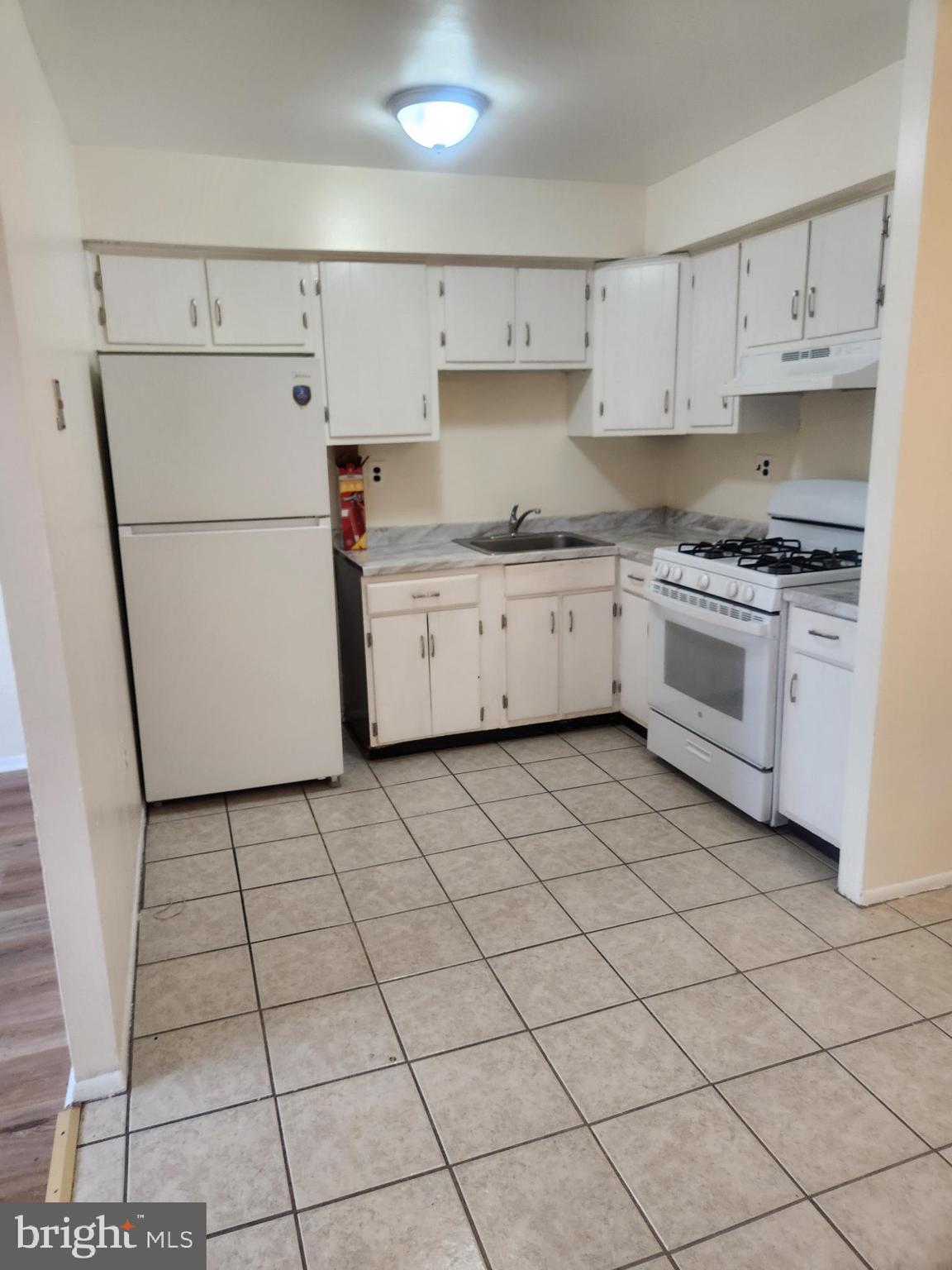 4320 Howell Street, Unit 1 Philadelphia, PA 19135 - Photo 6 of 19 a kitchen with a white cabinets and white appliances