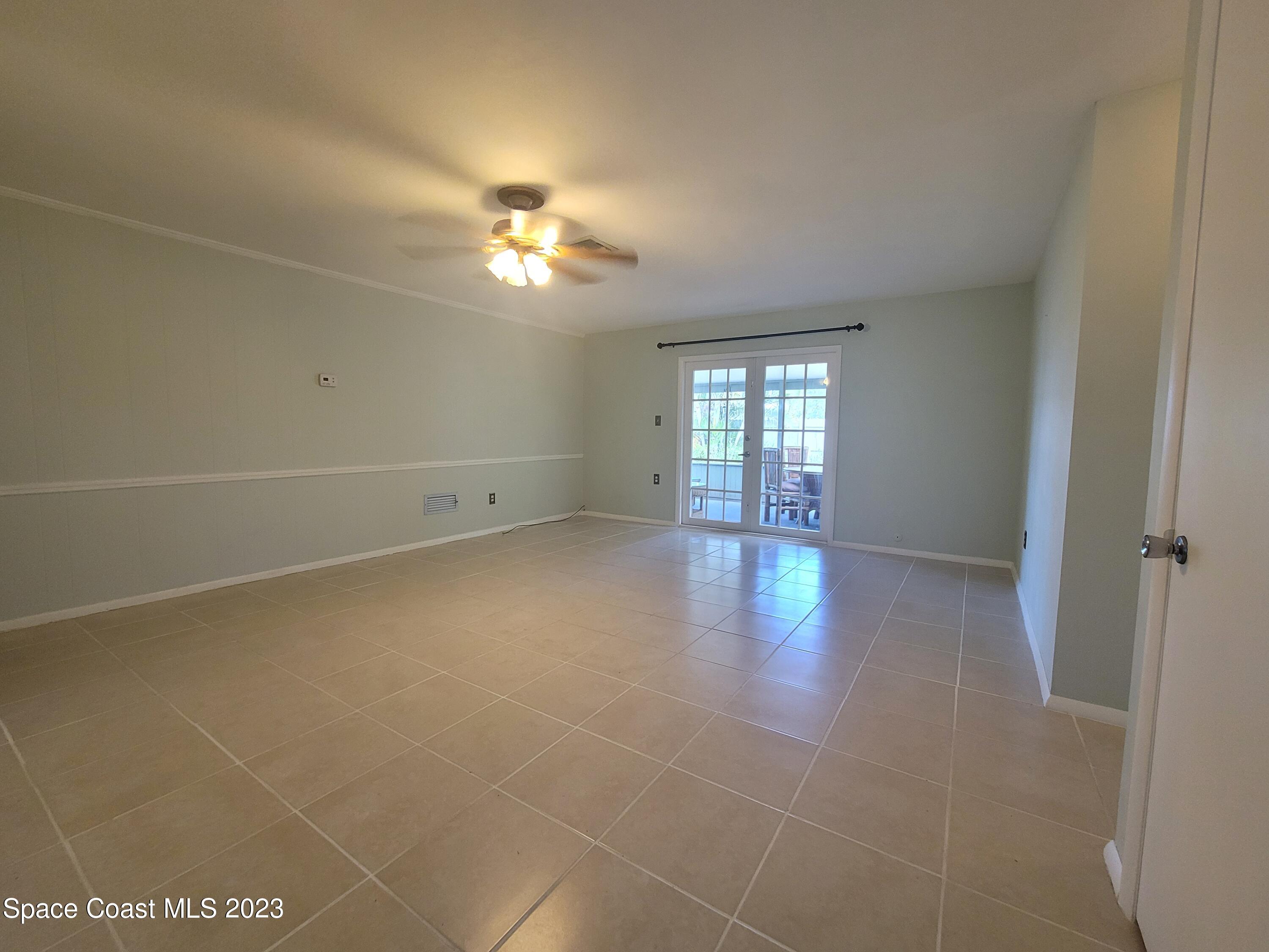 1107 Cable Lane Northeast Palm Bay, FL 32905 - Photo 5 of 17 an empty room with projector and fan