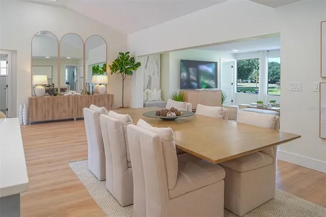 a living room with furniture a large window and wooden floor