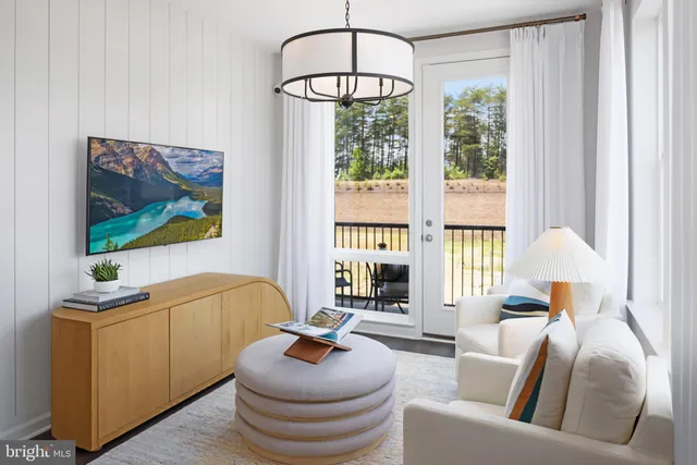 a living room with furniture a window and a flat screen tv