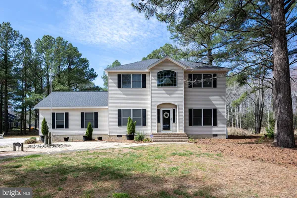 a front view of a house with yard and green space
