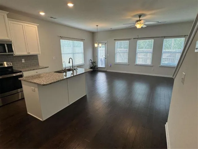 a kitchen with stainless steel appliances a refrigerator a stove top oven and a sink