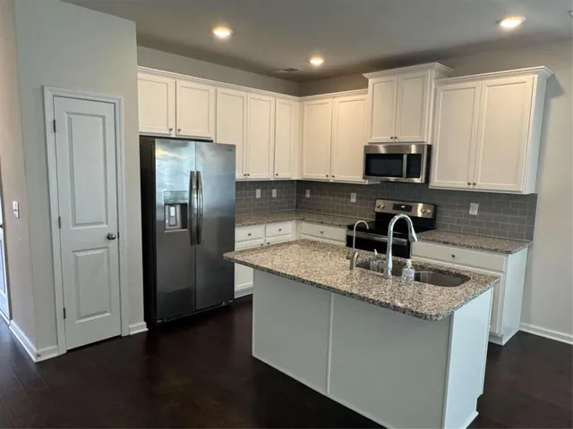 a kitchen with granite countertop a sink a stove cabinets and a granite counter tops