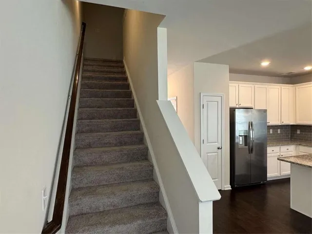 a view of an empty room with a chandelier fan