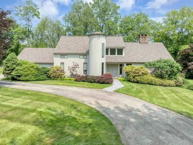a view of a house with a big yard plants and large trees