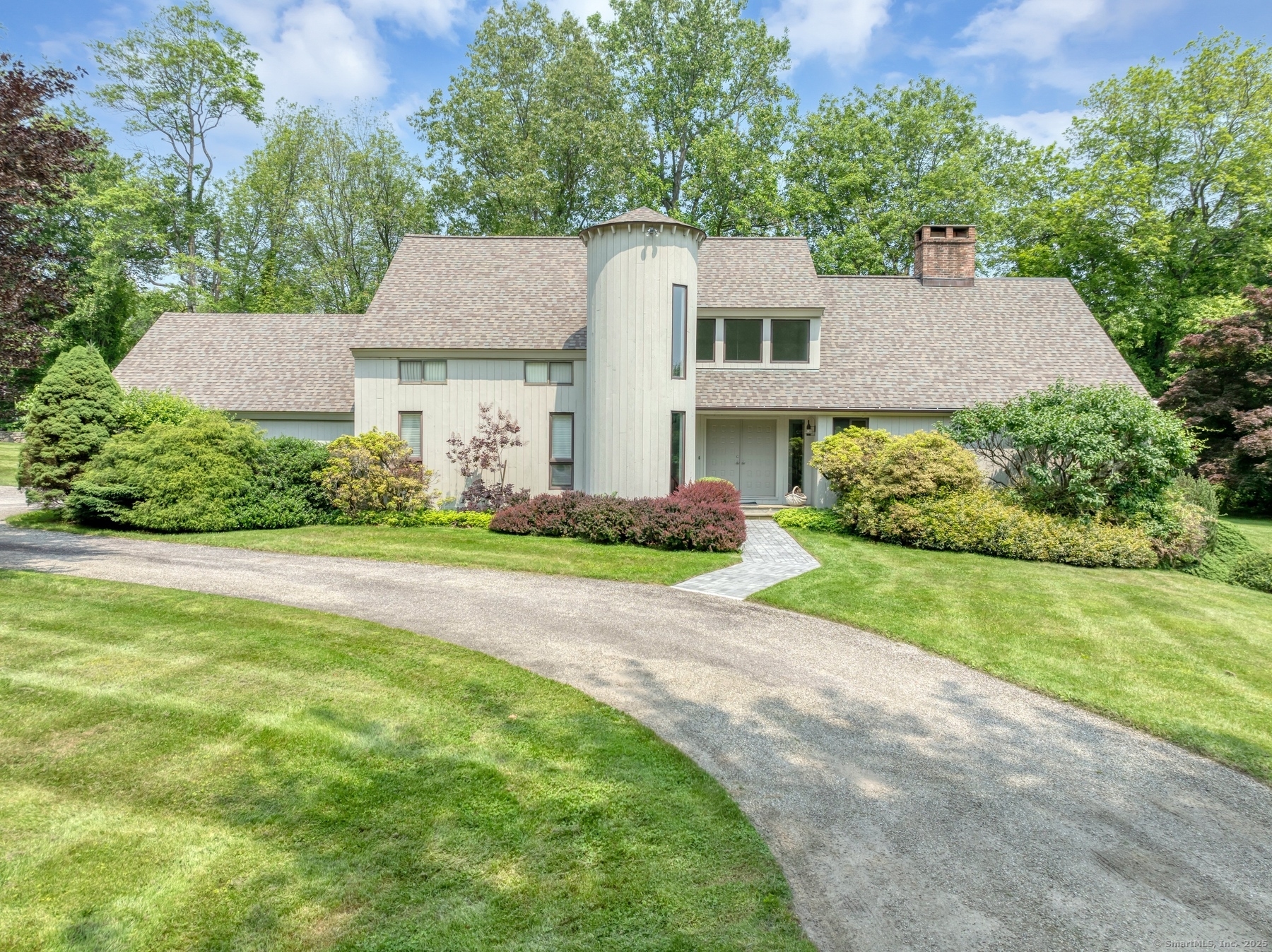 a view of a house with a big yard plants and large trees