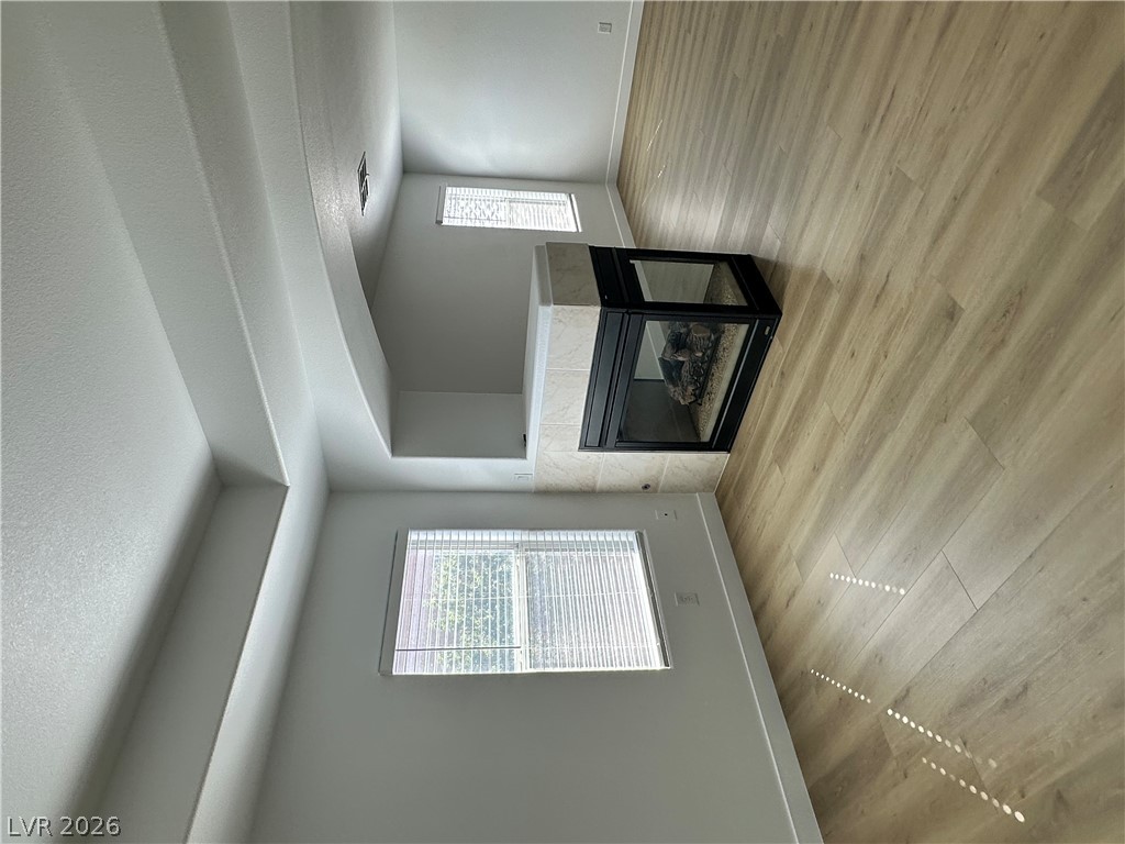 9639 West Post Road Las Vegas, NV 89148 - Photo 22 of 30 A modern three-sided fireplace anchors this airy living space complete with handsome wood-look flooring.