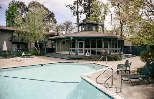 a view of house with swimming pool and outdoor seating