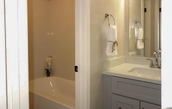 a bathroom with a granite countertop sink mirror and bathtub